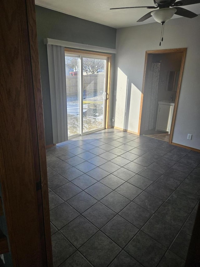 empty room with ceiling fan and tile patterned flooring