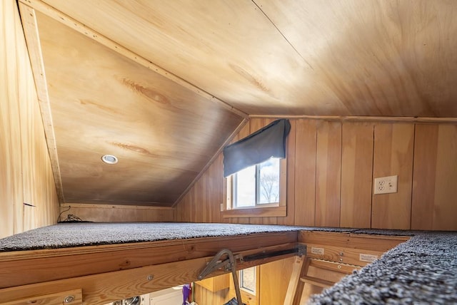 bonus room featuring lofted ceiling and wood walls