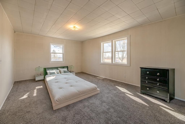 unfurnished bedroom with multiple windows, visible vents, and carpet flooring