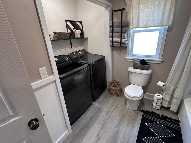 bathroom featuring washing machine and dryer, toilet, and wood-type flooring