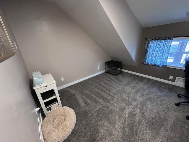 bonus room featuring lofted ceiling and dark colored carpet