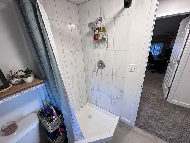 bathroom with toilet, a shower with curtain, and wood-type flooring