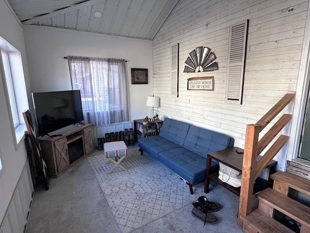 living room featuring lofted ceiling and wooden walls