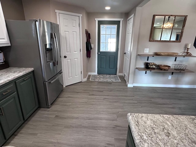 kitchen featuring stainless steel refrigerator with ice dispenser and light hardwood / wood-style floors