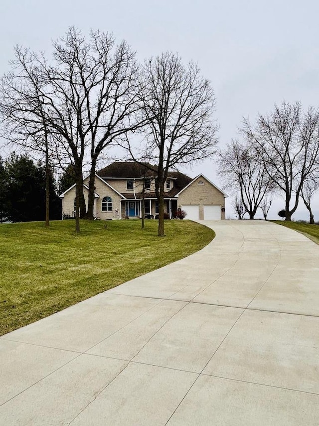 view of front of property with a front yard, concrete driveway, and an attached garage