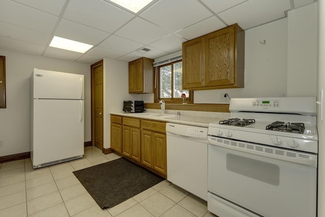 kitchen with sink, light tile patterned floors, a drop ceiling, and white appliances