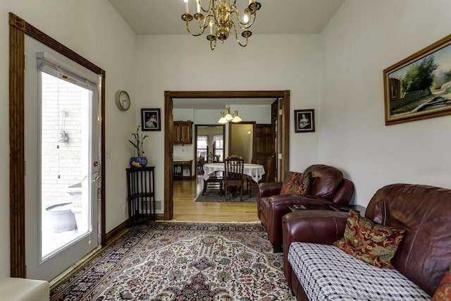 living area with a notable chandelier, wood finished floors, and baseboards