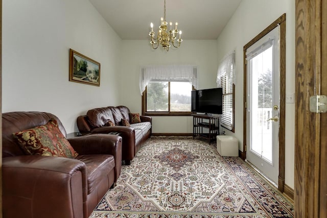 living area with baseboards and a chandelier