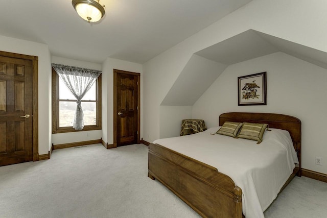 bedroom with baseboards, light carpet, and vaulted ceiling