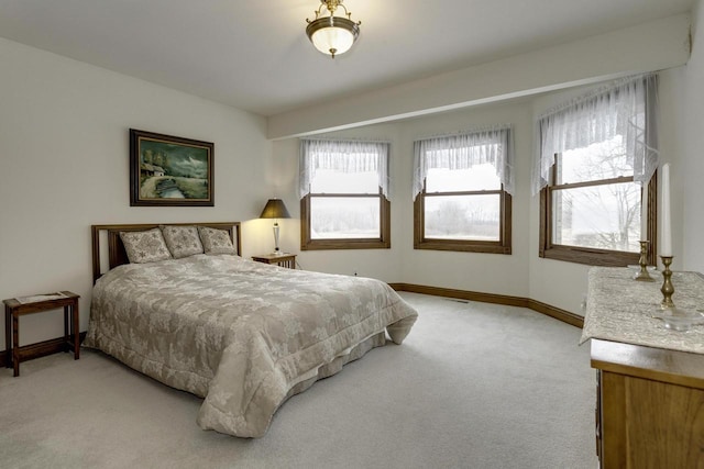 bedroom with baseboards and light carpet