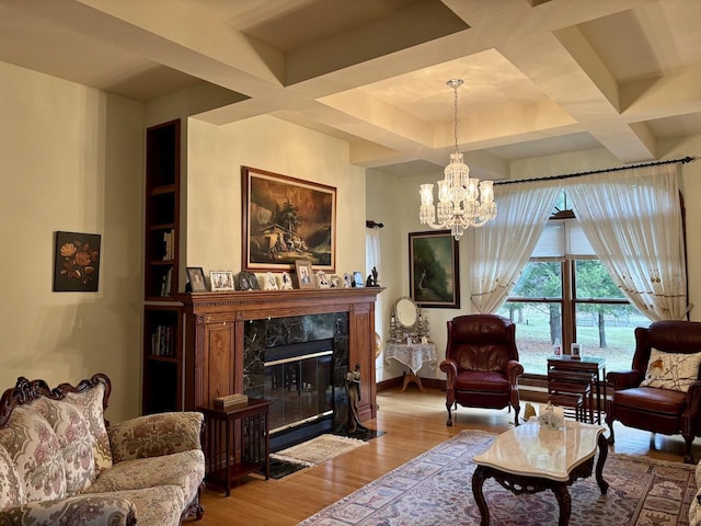 living room featuring baseboards, a chandelier, a fireplace, wood finished floors, and coffered ceiling