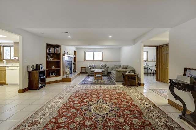 living room featuring light tile patterned flooring, plenty of natural light, and a fireplace