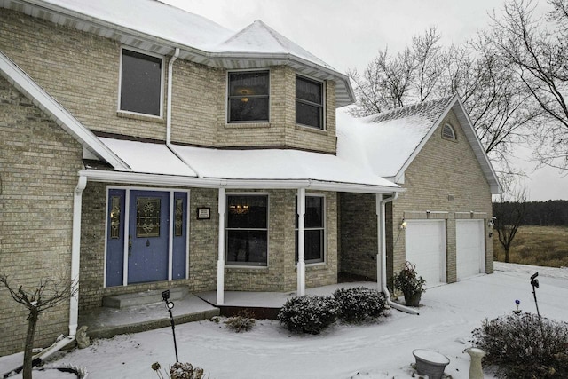 view of front of property with brick siding, covered porch, and a garage