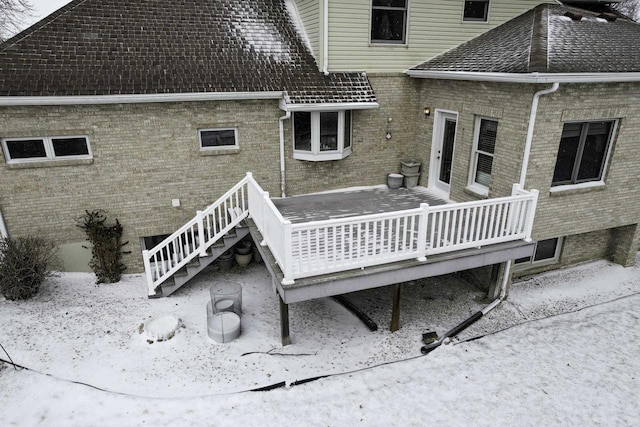 rear view of property with a deck and brick siding