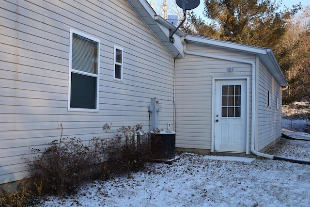 snow covered property with central AC unit