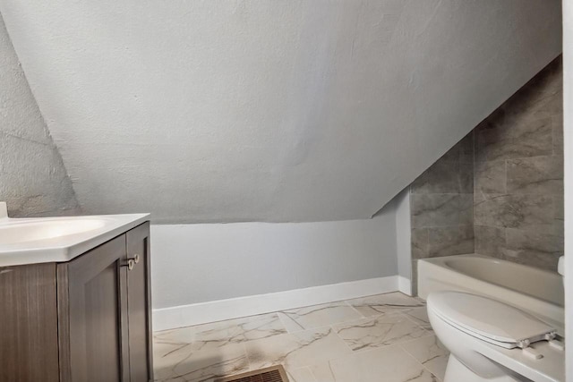 bathroom featuring toilet, vanity, a bath, and vaulted ceiling