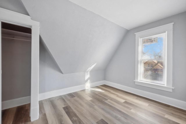 bonus room featuring lofted ceiling and light hardwood / wood-style flooring