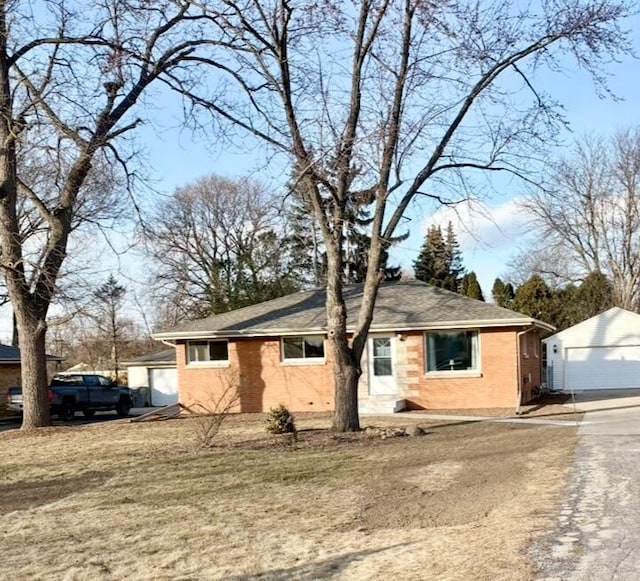 view of front facade featuring an outbuilding, a front yard, and a garage