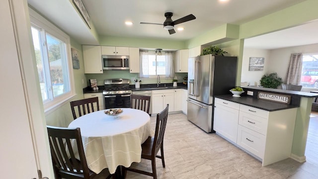 kitchen with sink, white cabinetry, kitchen peninsula, and stainless steel appliances