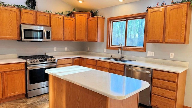 kitchen featuring appliances with stainless steel finishes, lofted ceiling, a center island, and sink