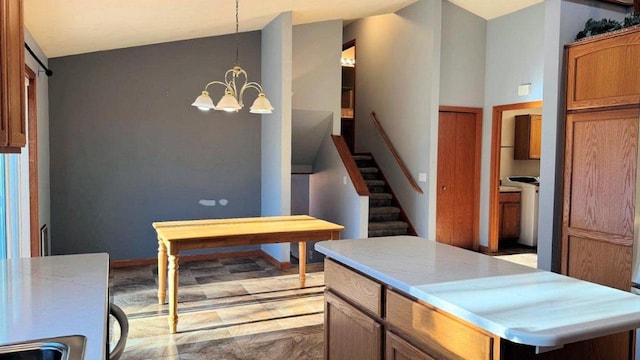 kitchen featuring pendant lighting, lofted ceiling, a notable chandelier, and a kitchen island