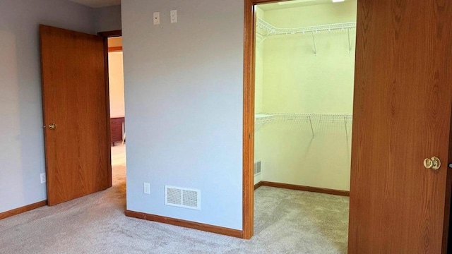 unfurnished bedroom featuring light colored carpet and a closet