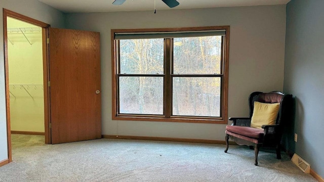 living area with ceiling fan and light colored carpet