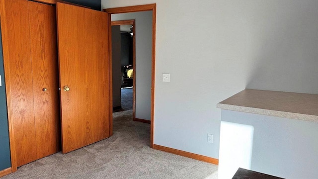 unfurnished bedroom with light colored carpet and a closet