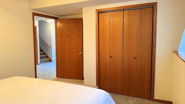 unfurnished bedroom featuring light carpet and a closet