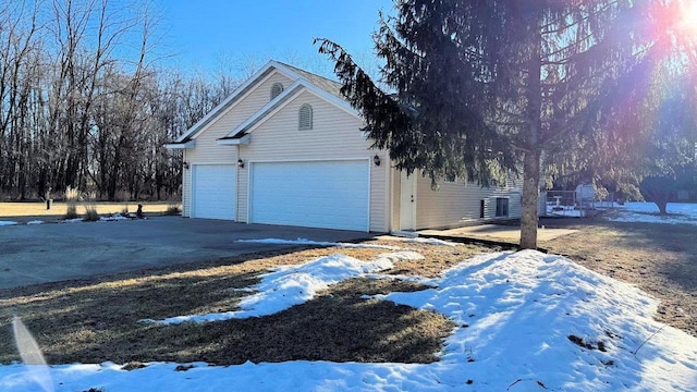 view of snowy exterior featuring a garage