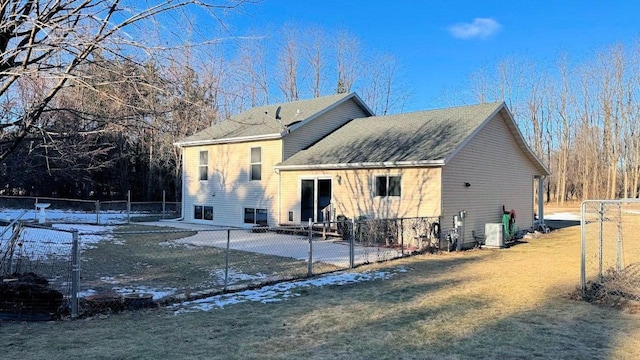 snow covered back of property featuring a lawn