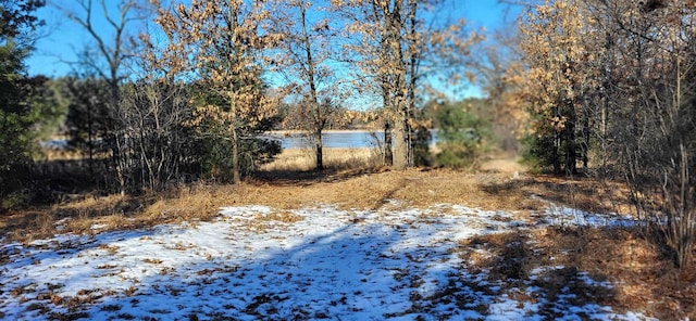 view of snow covered land with a water view