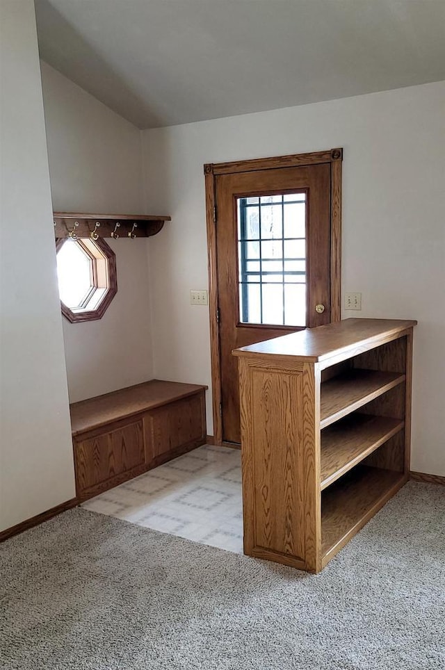 interior space with vaulted ceiling and light colored carpet