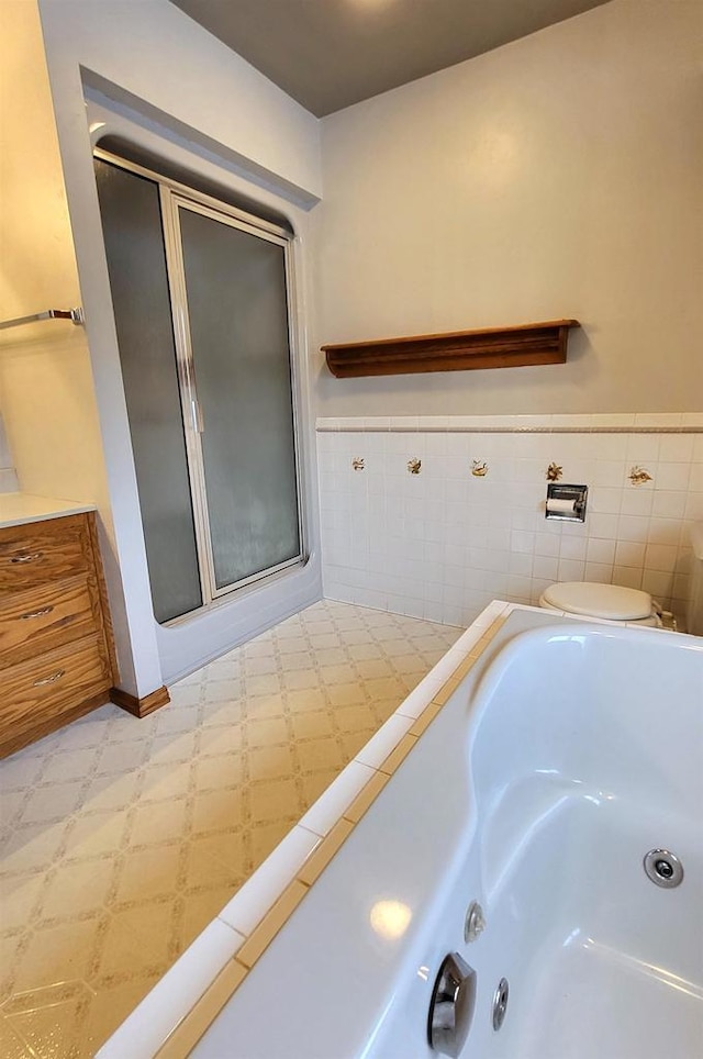 bathroom featuring toilet, tile walls, and shower with separate bathtub