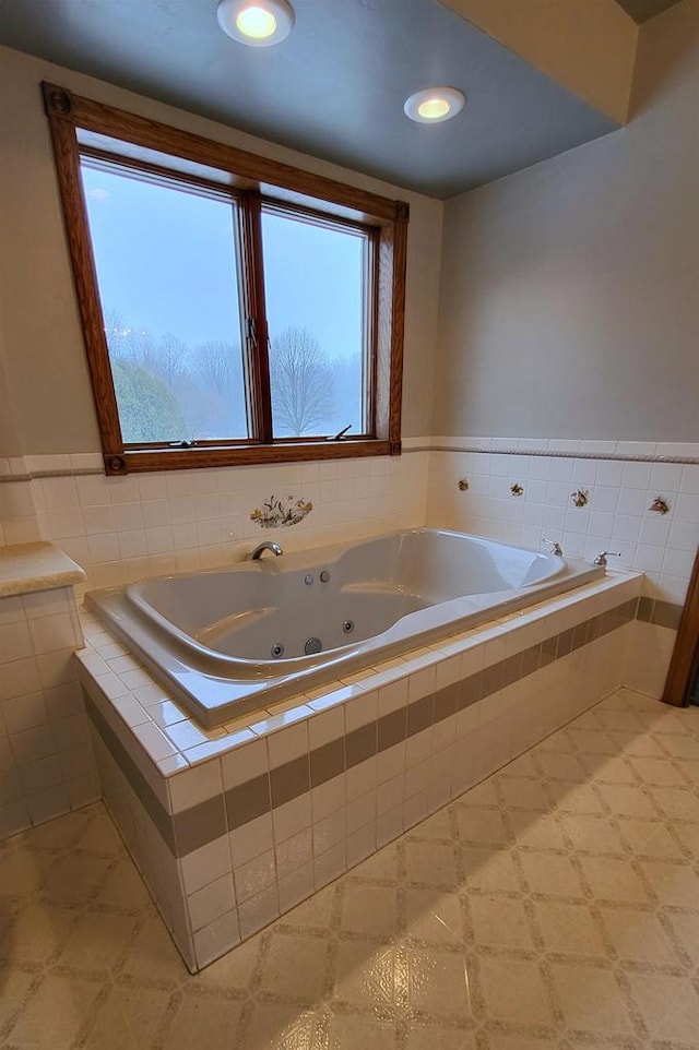 bathroom with tiled tub and a wealth of natural light