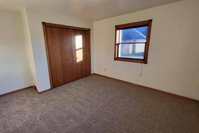 unfurnished bedroom with a closet, carpet floors, and multiple windows