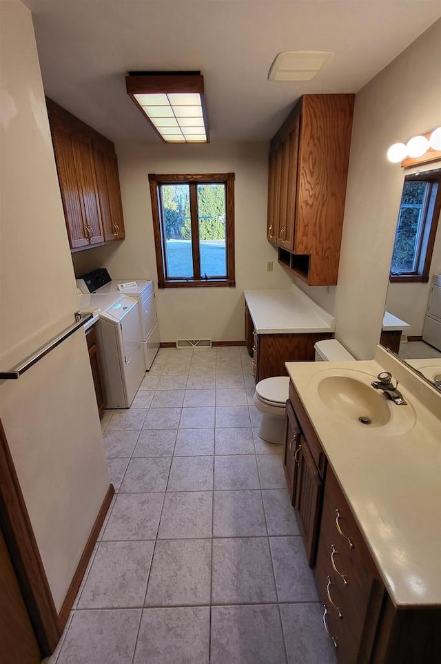 interior space with sink, light tile patterned floors, and washing machine and dryer