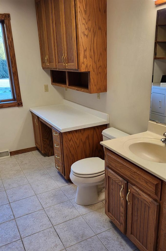 bathroom featuring vanity, washer / clothes dryer, tile patterned floors, and toilet