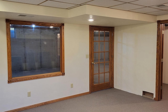 carpeted spare room with a paneled ceiling