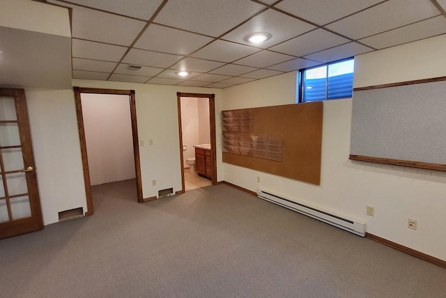 basement featuring a baseboard heating unit, light carpet, and a drop ceiling