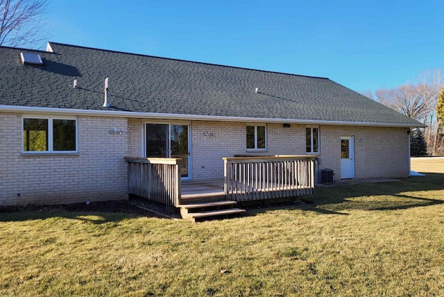 back of property featuring a deck and a lawn