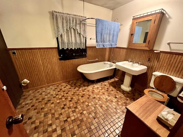 bathroom with toilet, tile patterned floors, and a bath