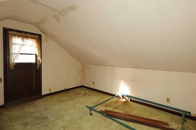 bonus room with lofted ceiling and light carpet