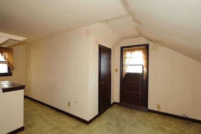 bonus room featuring light colored carpet and lofted ceiling