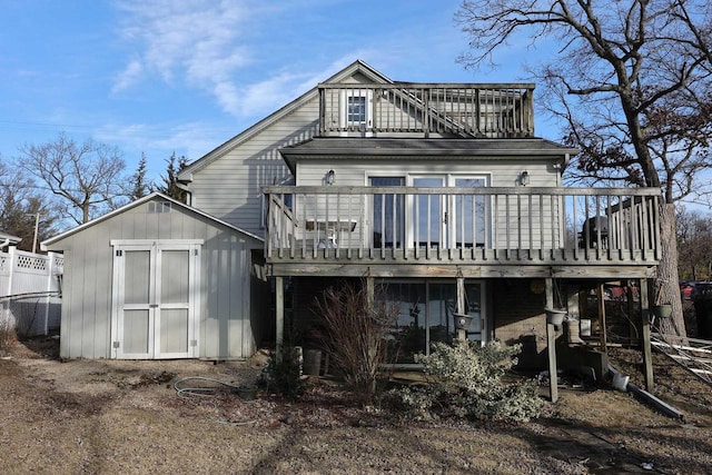 rear view of property with a deck and a storage unit