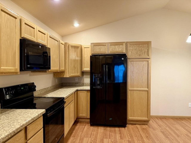 kitchen with light brown cabinetry, light hardwood / wood-style floors, black appliances, and vaulted ceiling