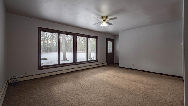 carpeted spare room with ceiling fan and baseboard heating