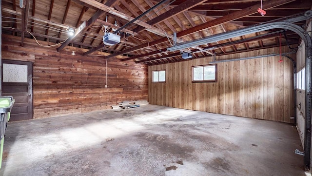 garage with a garage door opener and wooden walls