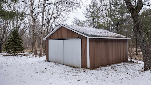 snow covered structure featuring a garage