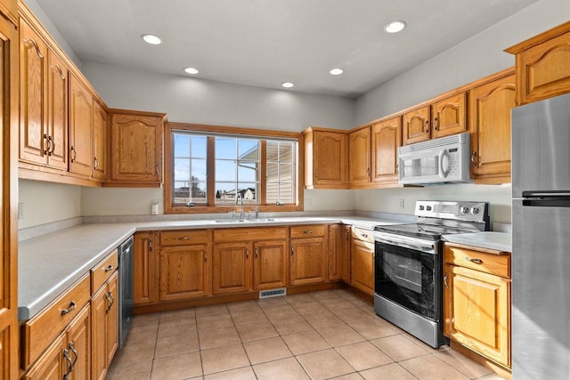 kitchen featuring appliances with stainless steel finishes, sink, and light tile patterned flooring